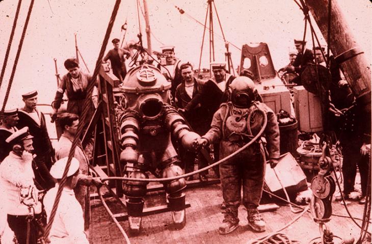 استكشاف جي. بيريز مرتديًا لباس غوص طراز ١- جو [وحدة عالمية لقياس الضغط] من شركة تريتونيا، لحطام سفينة لوسيتانيا في ١٩٣٥. جيم جاريت كان هو الغواص الرئيسي وغاص لمسافة ٣١٢ قدم.