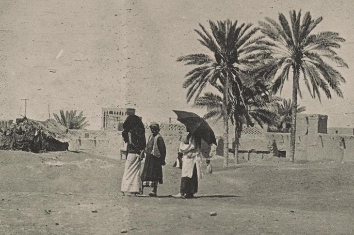 جزء من صورة فوتوغرافية لمنظر في بندر عباس، إيران، مايو ١٩١٧. يستخدم الشخص الموجود في أقصى اليمين مظلةً لحماية نفسه من حرارة الشمس. Photo 496/6/14